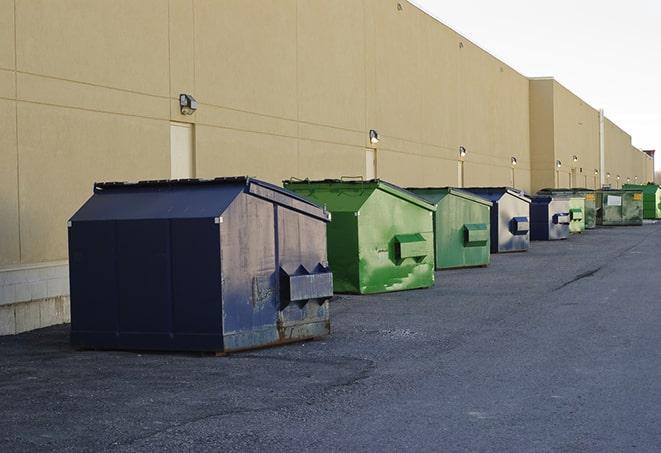 a red construction dumpster placed in front of a building under construction in Aitkin